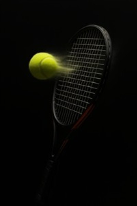 Tennisbold i Fuld Bevægelse - Oplev dynamikken i tennis med dette fantastiske billede af en strålende tennisbold, der suser mod en ketsjer. Den mørke baggrund fremhæver det intense øjeblik og tilfører fart og energi til dit rum.